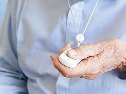 Senior hält Hausnotrufsender in der Hand